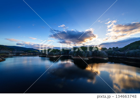 水不足の奈良布目ダム師走の夕景 大空を渡る雲と山際で輝く夕日に照らされる布目湖② 水不足の奈良布目ダム師走の夕景 大空を渡る雲と山際で輝く夕日に照らされる布目湖② 134663748