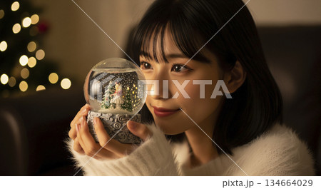 ガラスのスノードームを両手で持つ女性 134664029