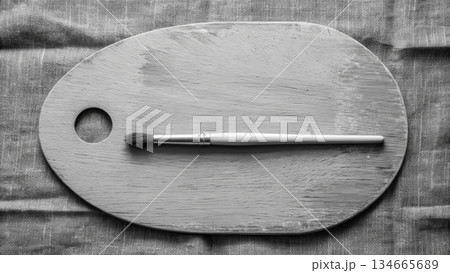 Wooden palette with a brush on a plain background during a creative session at home 134665689