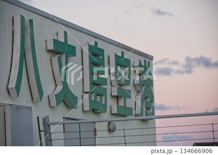 離島の空港建物に掲げられた文字看板と夕空 134666906
