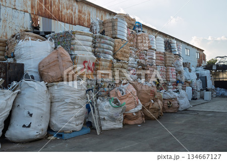 夕暮れの資源リサイクル施設に山積みされた廃プラスチックの圧縮ベールとフレコンバッグ(環境・資源) 夕暮れの資源リサイクル施設に山積みされた廃プラスチックの圧縮ベールとフレコンバッグ(環境・資源) 134667127
