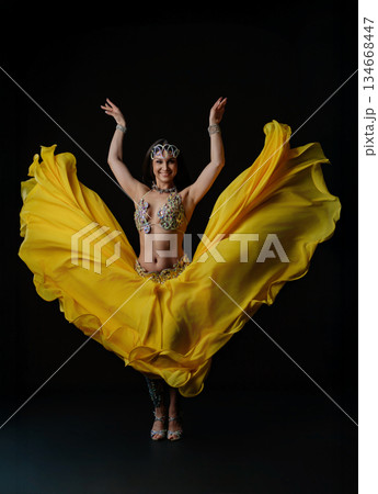 Woman performs dance with snake in colorful outfit during evening show Woman performs dance with snake in colorful outfit during evening show 134668447