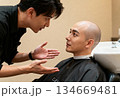 Barbershop conversation during haircut for bald client in modern salon setting 134669481