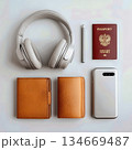 Essential Travel Items: A Collection of Headphones, Passports, Wallets, and a Smartphone 134669487
