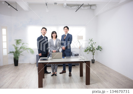 オフィスで並ぶ日本人ビジネスチームの男女3人のカメラ目線 信頼感のある中小企業や商工会などのイメージ オフィスで並ぶ日本人ビジネスチームの男女3人のカメラ目線 信頼感のある中小企業や商工会などのイメージ 134670731