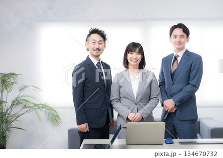 オフィスで並ぶ日本人ビジネスチームの男女3人のカメラ目線 信頼感のある中小企業や商工会などのイメージ オフィスで並ぶ日本人ビジネスチームの男女3人のカメラ目線 信頼感のある中小企業や商工会などのイメージ 134670732