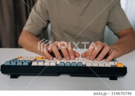 Person hands typing swiftly on stylish wireless mechanical keyboard with colored keycaps, demonstrating efficient digital work, productivity and modern technology use in home office environment. Person hands typing swiftly on stylish wireless mechanical keyboard with colored keycaps, demonstrating efficient digital work, productivity and modern technology use in home office environment. 134670746