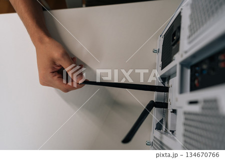 Top view of male hand installing network antenna into desktop computer, establishing wireless internet connection for device and enabling high-speed data transfer. 134670766