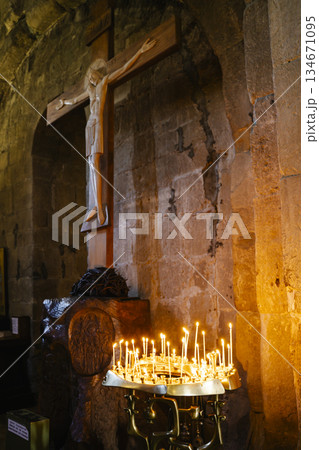 Candles in a Christian Orthodox church background. Flame of candles in the dark sacred interior of the temple 134671095