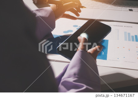 Above table with finance papers, graphs and big data during teamwork meeting with accounting or marketing team discussing budget, strategy or growth development. Closeup of SEO team doing research 134671167