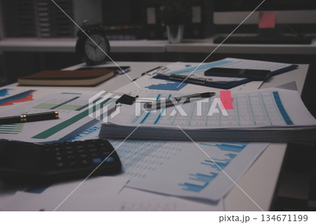 Above table with finance papers, graphs and big data during teamwork meeting with accounting or marketing team discussing budget, strategy or growth development. Closeup of SEO team doing research 134671199