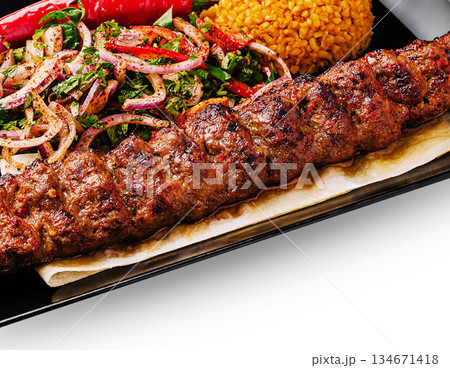 Delicious kebab served with rice and fresh salad at a local restaurant 134671418