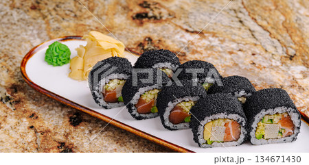 Unique sushi rolls displayed on a plate with wasabi and ginger 134671430