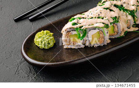 Sushi roll served on a dark plate with wasabi and pickled ginger Sushi roll served on a dark plate with wasabi and pickled ginger 134671455