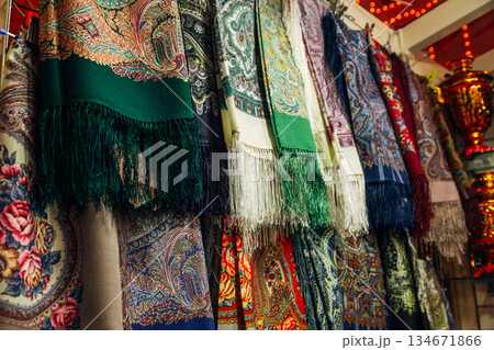 Russian colorful traditional scarfs for sale in a gift shop 134671866