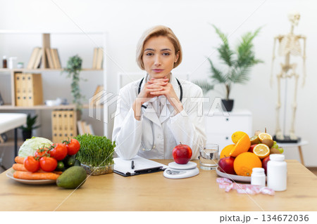 A dietitian sits at a desk surrounded by fresh fruits, vegetables, and supplements, promoting healthy eating habits. A dietitian sits at a desk surrounded by fresh fruits, vegetables, and supplements, promoting healthy eating habits. 134672036