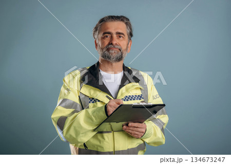 Police officer. Senior man is standing in the studio against background Police officer. Senior man is standing in the studio against background 134673247