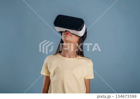 Virtual reality headset. Young girl is against background 134673399