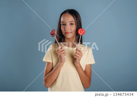 Sweet candies. Young girl is against background 134673434