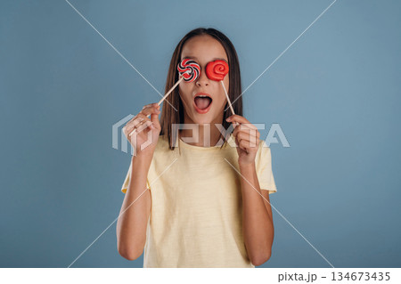 Sweet candies. Young girl is against background 134673435