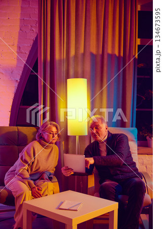 Elderly couple checking weather forecast together using digital tablet. Elderly couple checking weather forecast together using digital tablet. 134673595
