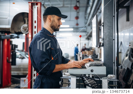 Standing by the display. Mechanic working in a car service station 134673714