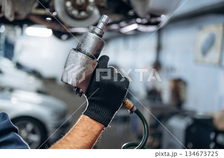 Close up view of mechanic in car service station Close up view of mechanic in car service station 134673725