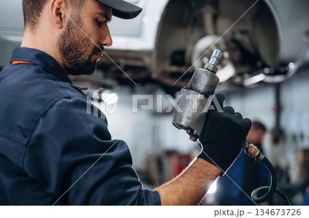 Special tool in hand. Mechanic working in a car service station Special tool in hand. Mechanic working in a car service station 134673726