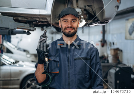 Professional equipment. Mechanic working in a car service station Professional equipment. Mechanic working in a car service station 134673730