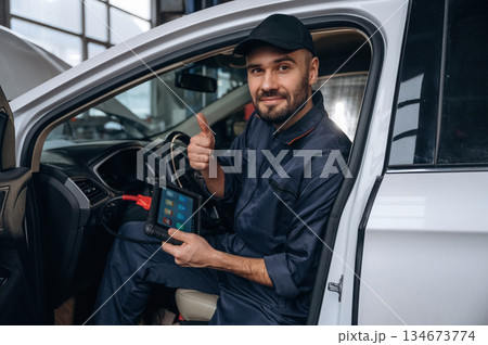 Thumb up, everything will be done. Mechanic working in a car service station Thumb up, everything will be done. Mechanic working in a car service station 134673774