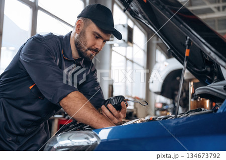 Focused at work. Mechanic is in a car service station 134673792