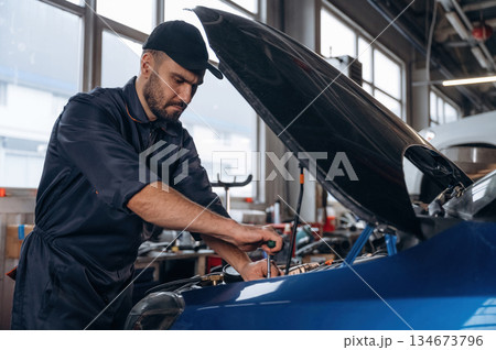 Service station, busy. Mechanic is working Service station, busy. Mechanic is working 134673796
