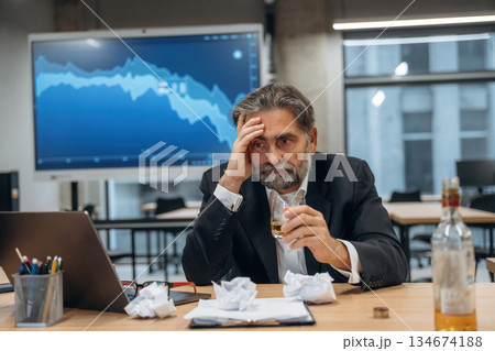 Alcohol on the work, drinking, depression. Senior man is in the modern office 134674188