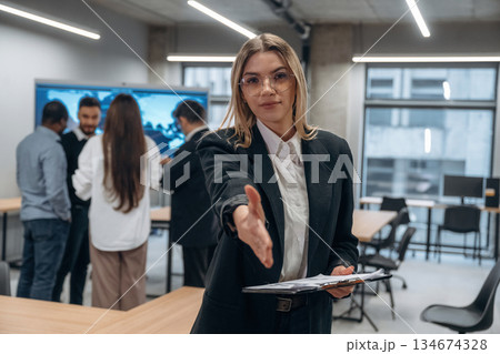 Front view of woman. Group of office workers are indoors together Front view of woman. Group of office workers are indoors together 134674328
