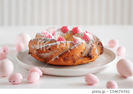 Traditional Easter cakes with icing decorated candies on white wooden table 134674392