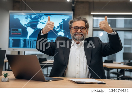 Happy, hands up, success. Senior man is in the modern office 134674422