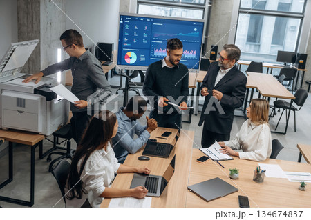Professional company. Group of office workers are indoors together Professional company. Group of office workers are indoors together 134674837