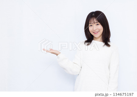 笑顔で紹介をしている女性 134675197