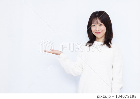 笑顔で紹介をしている女性 笑顔で紹介をしている女性 134675198