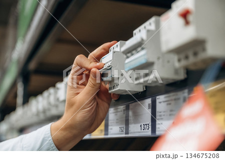 Electrical switches. Detailed close up view of man's hand in the hardware store 134675208