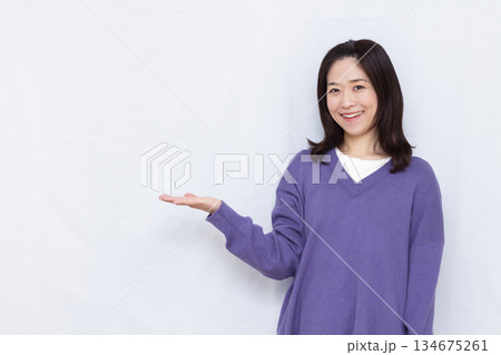 笑顔で紹介をしている女性 134675261