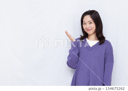 笑顔で紹介をしている女性 笑顔で紹介をしている女性 134675262