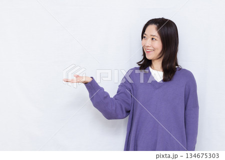 笑顔で紹介をしている女性 134675303