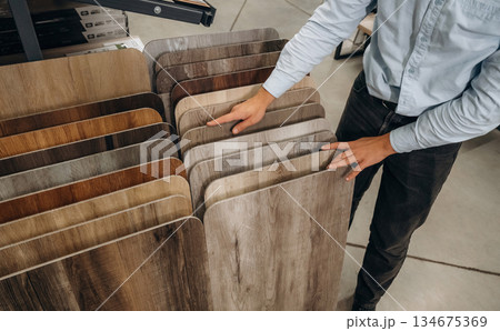 Stack of parquet colors examples. Detailed close up view of man's hand in the hardware store 134675369