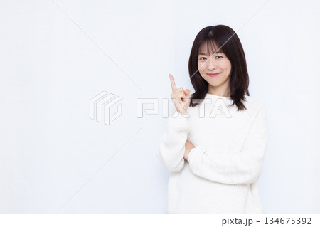 笑顔で人差し指を立てている女性 134675392