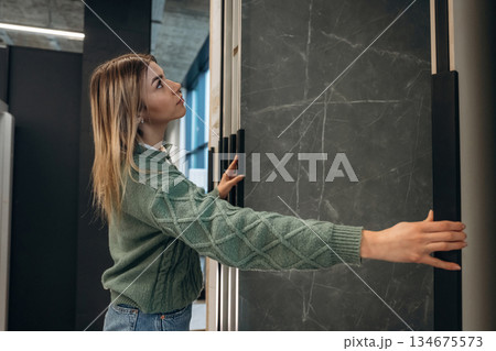 Searching for perfect plate for kitchen. Woman is in the hardware store, shopping conception Searching for perfect plate for kitchen. Woman is in the hardware store, shopping conception 134675573