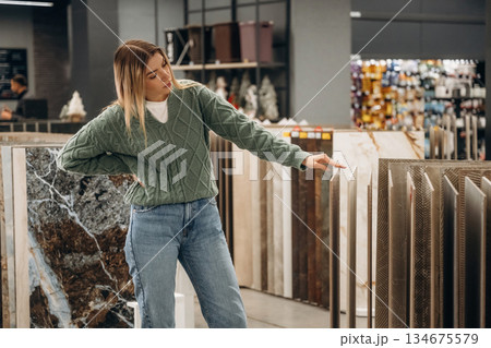 Searching for perfect plate for kitchen. Woman is in the hardware store, shopping conception 134675579