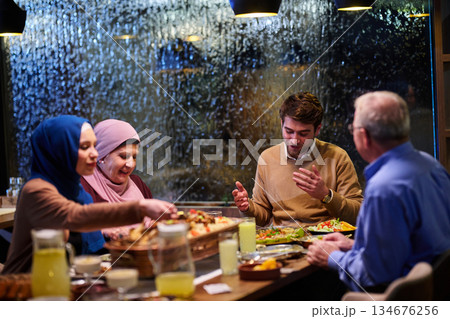 Gathering of family for iftar dinner during Ramadan in a cozy restaurant with rain on the window Gathering of family for iftar dinner during Ramadan in a cozy restaurant with rain on the window 134676256