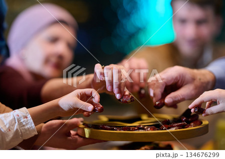 Families sharing dates during iftar time in a lively setting celebrating Ramadan traditions Families sharing dates during iftar time in a lively setting celebrating Ramadan traditions 134676299
