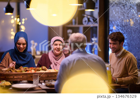 Family gathers for iftar during Ramadan in a warm restaurant setting Family gathers for iftar during Ramadan in a warm restaurant setting 134676329